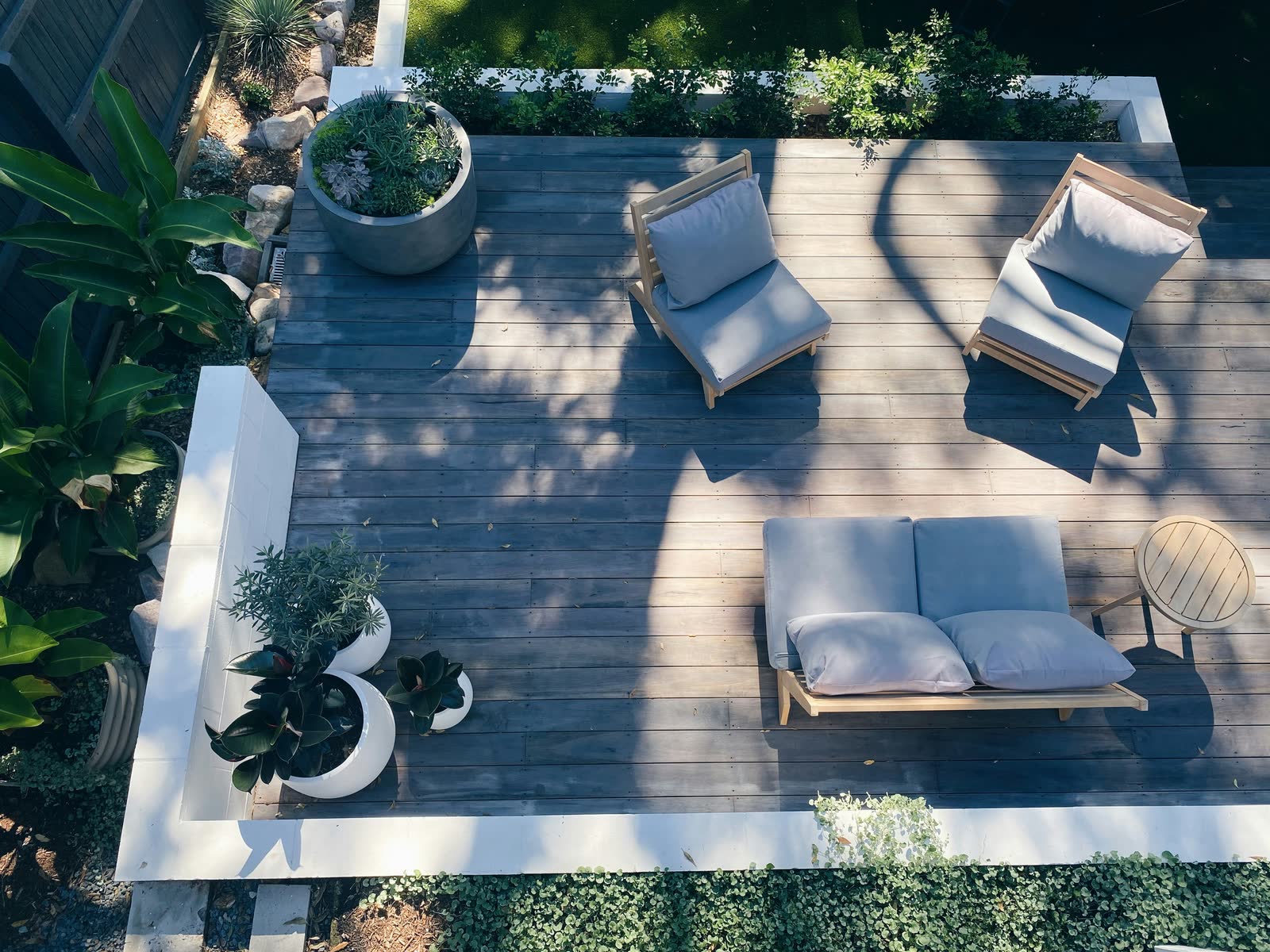 Finished outdoor deck with structured planters and lounge seating.